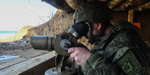 Ein russischer Soldat schaut durch ein Fernglas
