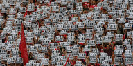 Fußballfans strecken bei einer Protestaktion kollektiv beschriebene Zettel hoch