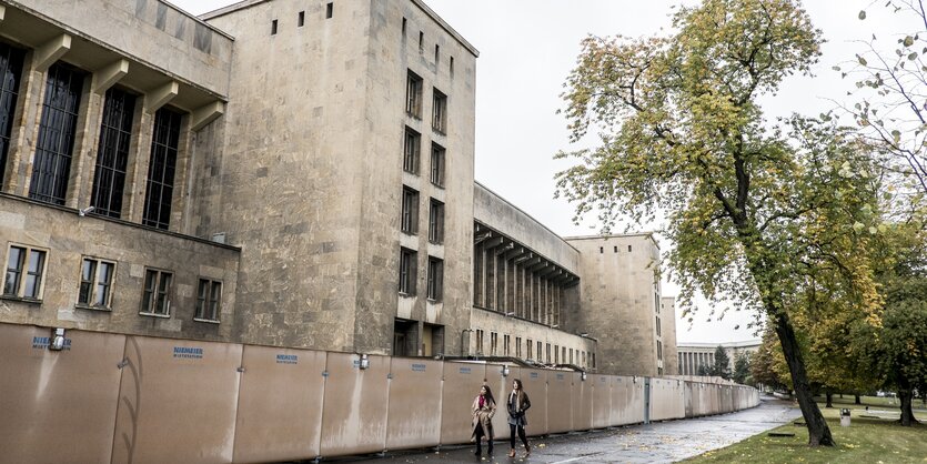 Zwei Passantinnen laufen am ehemaligen Flughafen Tempelhof entlang