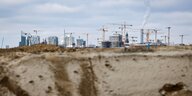 Blick auf eine Baugrube, im Hintergrund viele Kräne und die Hamburger Hafencity
