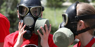 Zwei Kinder mit Gasmasken
