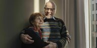 Ein älteres Paar schaut in die Kamera und lacht