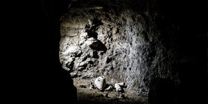 Am Eingang eines Tunnels in den Licht fällt, liegen zerbrochene, antike Gegenstände