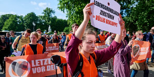 Demonstrierende für die Letzte Generation, sie halten Zettel in die Höhe, die die Klimapolitik der Ampelkoalition kritisieren