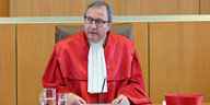 Andreas Voßkuhle trägt das rote Gewand der Verfassungsrichter, sitzt und verkündet ein Urteil