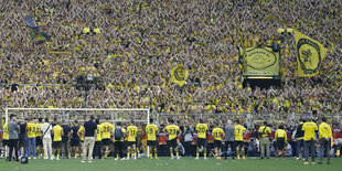 Die Mannschaft von Borussia Dortmund baut sich vor der Südtribünbe auf und lässt sich feiern