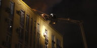 Feuerwehrleute löschen ein Feuer auf dem Dach eines Wohnhauses nach einem Drohnenangriff