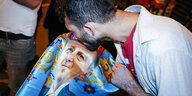Mann küsst Konterfeit von Erdogan