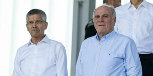 Die FC Bayern-Funktionäre Uli Hoeneß und Herbert Hainer stehen mit weißen Hemden auf der Tribüne