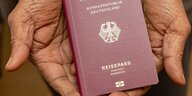 Hände halten einen deutschen Reisepass