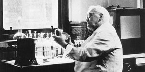 Sir Alexander Fleming hält eine Petrischale in den Händen