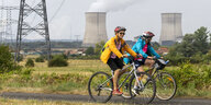 Radler vor einem Atomkraftwerk