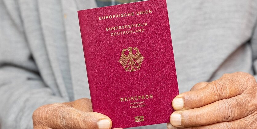 Hände halten einen deutschen Reisepass