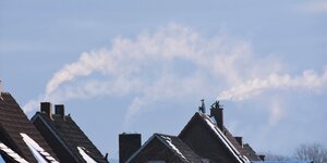Rauchende Schornsteine auf Hausdächern von Einfamilienhäusern
