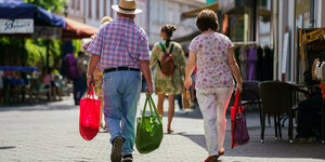 Ein Mann und eine Frau mit Einkaufstaschen in der Augsburger Fussgängerzone