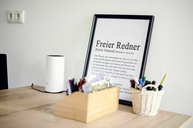 "Freier Redner" - eine Beschreibung seines Wirkens steht als Text in einem schwarzen Bilderrahmen auf einem Tisch