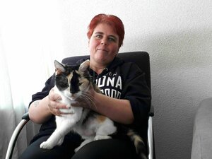 Porträt von Harma Kempinga - sie sitzt mit ihrer Katze auf einem Stuhl