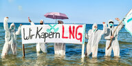 Aktivistinnen im Wasser halten ein Plakat worauf steht "Wir Kapern LNG"