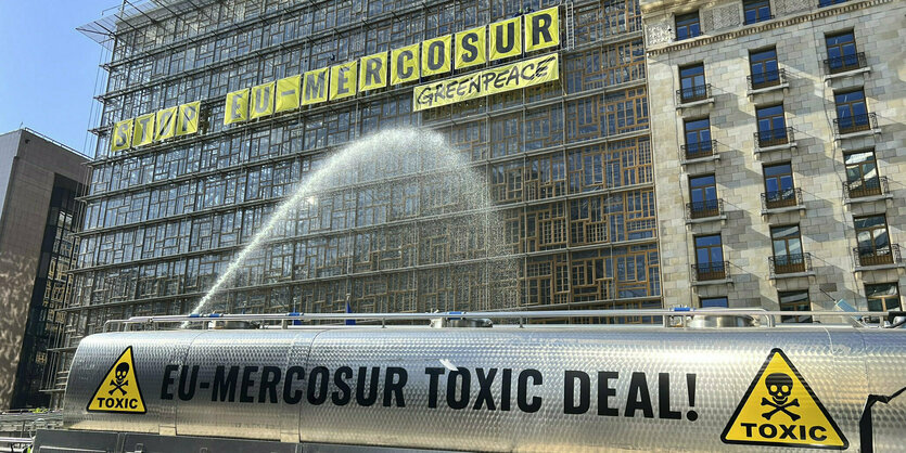 Silberner Tanker vor dem EU-Ratsgebäude in Brüssel mit der Aufschrift Greenpeace, Stop EU-Mercosur Toxic deal