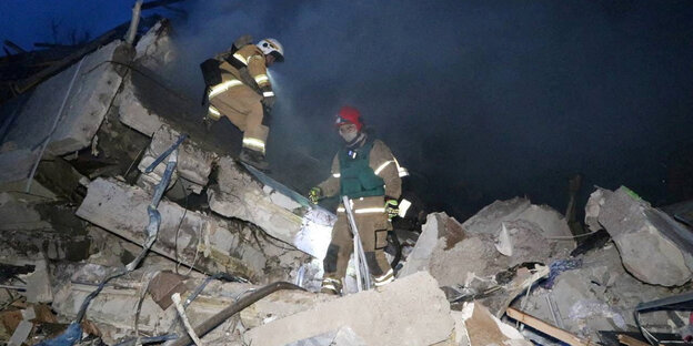 Rettungskräfte arbeiten auf den Trümmern eines Wohnhauses in Dnipro