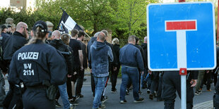 Rechtsextreme vor einem Sackgassenschild