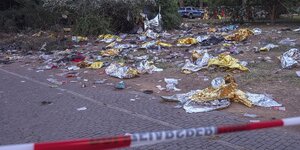Müll liegt hinter der Polizeiabsperrung, wo diese in der Nacht 1.000 Menschen festhielt