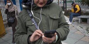 Menschen mit Smartphones auf einer Straße