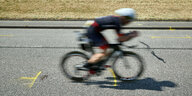 Ein Fahrradfahrer fährt auf einer Straße, auf der Markierungen angebracht sind