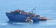 it Schlauchbooten retten Mitarbeiter der Organisation Ärzte ohne Grenzen Migranten und Flüchtlinge im Mittelmeer von einem Boot in Seenot.