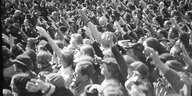 Eine große Menschenmenge, die Menschen zeigen den Hitlergruß
