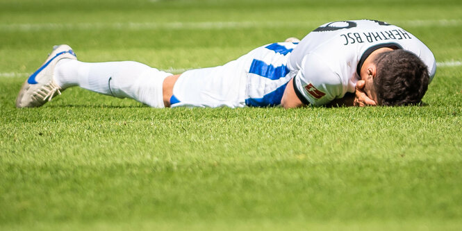 Ein Hertha-Spieler liegt langgestreckt auf dem Speilfeld