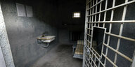 Gefängniszelle mit Waschbecken, Guckloch, BEtt, eine halb geöffnete Gittertür