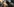 Zwei Köpfe mit Dreadlocks vor zwei Köpfen von behelmten Polizisten