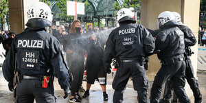 Einsatzkräfte der Polizei sprühen bei einer Demonstration Reizmittel auf eine junge Frau.