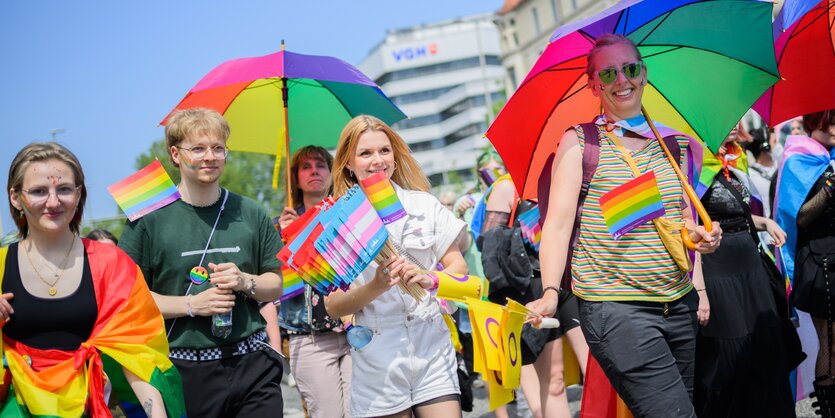 bund gekleidete Menschen mit Fahnen, lachend