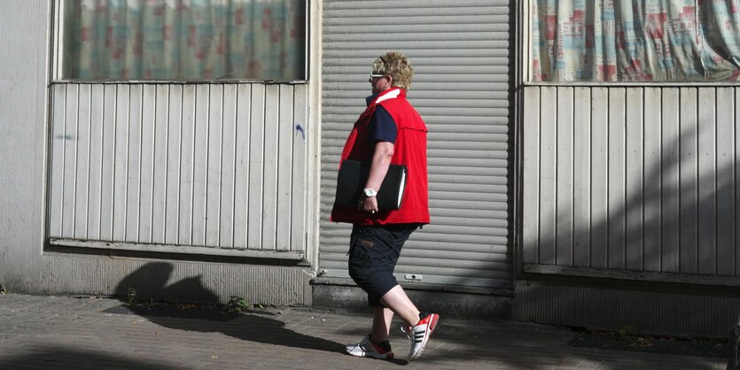 Frau in Casualwear vor einem dicht gemachten Laden