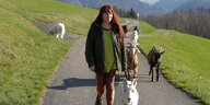 Eleonora Zickenheiner unterwegs mit ihren Ziegen auf einer kleinen Straße in hügeliger Landschaft