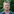 Baumpfleger Jörg Cremer steht vor einem grünen Strauch, hat kurze graue Haare, ein dunkelblaues Polohemd an und lächelt leicht