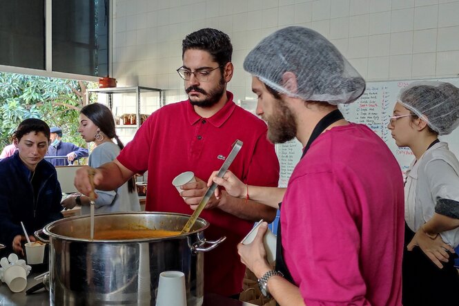 Zwei Köche rühren in einer Suppe rum