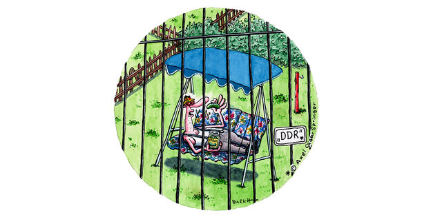 Ein Cartoon. Ein Mann, der Gurken isst, hinter Gittern, daran ein Schild mit der Aufschrift DDR.