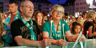 Auf dem Evangelischen Kirchentag in Nürnberg stehen Gläubige mit Kerzen an einer Bühnenabsperrung und singen.