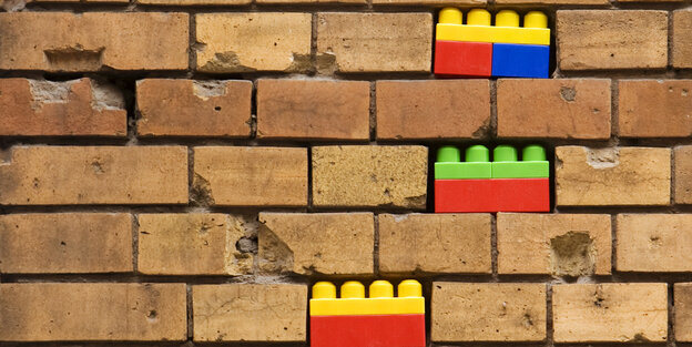 Bunte Legosteine in einer Ziegelmauer