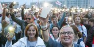 Menschen protestieren und hlaten ihre leuchtenden Smartphones in die Höhe