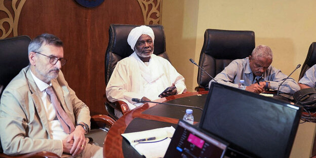 Drei Männer sitzen an einem Verhandlungstisch in Port Sudan im Mai 2023: Volker Perthes, Sudans Finanzminister und eine weitere, unbekannte Person