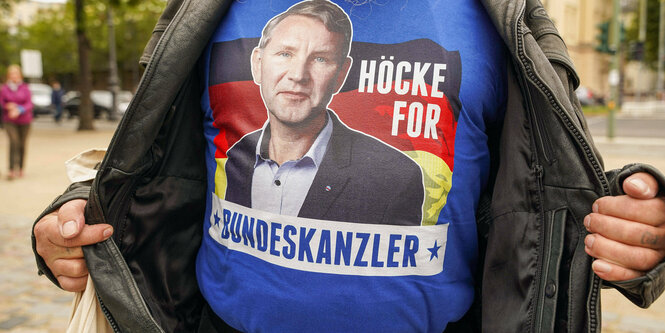 Ein Mann mit einem blauem T-Shirt und Aufdruck "Höcke for Bundeskanzler"