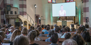 Besucher und Besucherinnen während des KI erstellten Gottesdiensts in einer Fürther Kirche