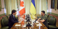 Kanadas Premierminister Justin Trudeau und Ukraines Präsident Wolodimir Selenski sitzen gemeinsam an einem Tisch