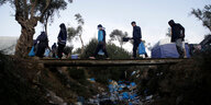 Migranten auf einer Brücke.
