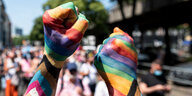 Zwei Teilnehmer der «Pride Berlin: Save our Community, Save our Pride» halten ihre Faust in die Höhe, die in Regenbogenfarbe angemalt sind.