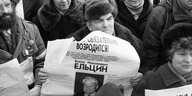 Blick in eine winterlich gekleidete Menschenmenge, ein Mann hält ein Plakat mit dem Porträt Boris Jelzins in der Hand